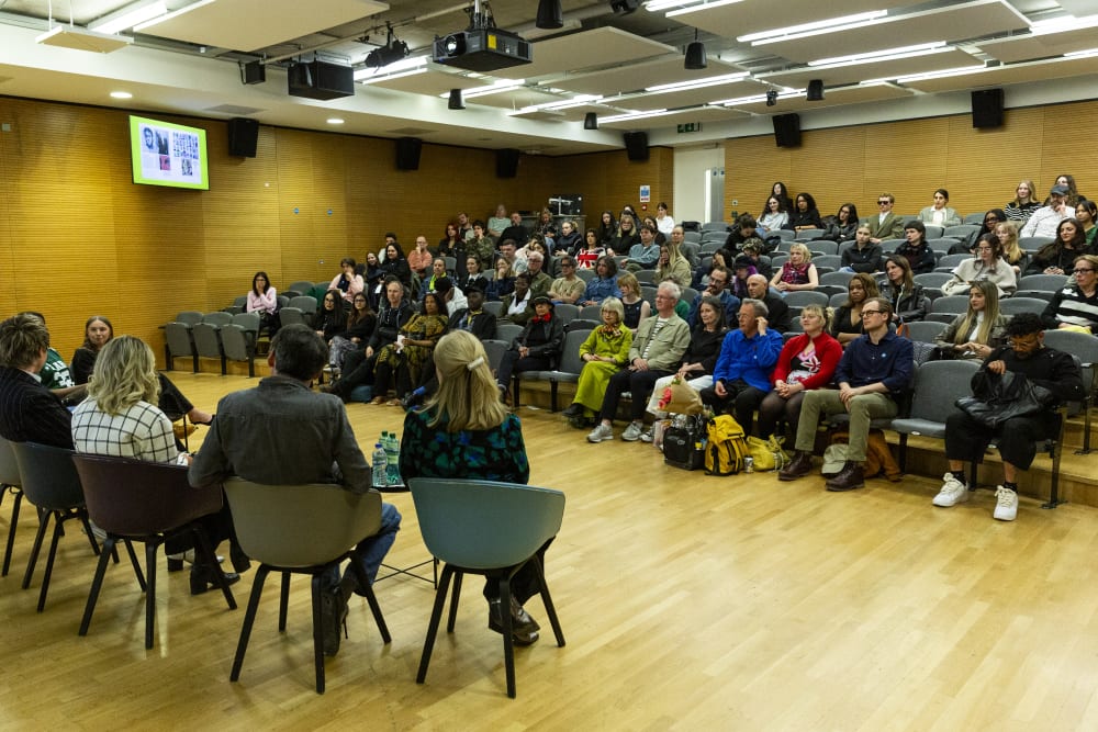 People sitting in a lecture theatre looking at the stage