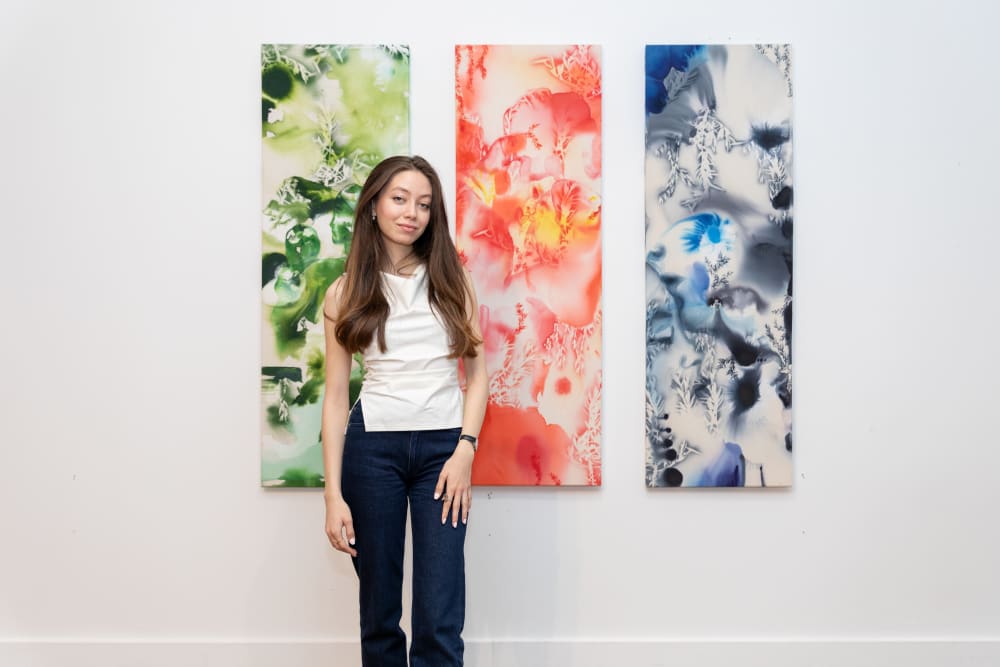Zeina standing in front of her triptych of work