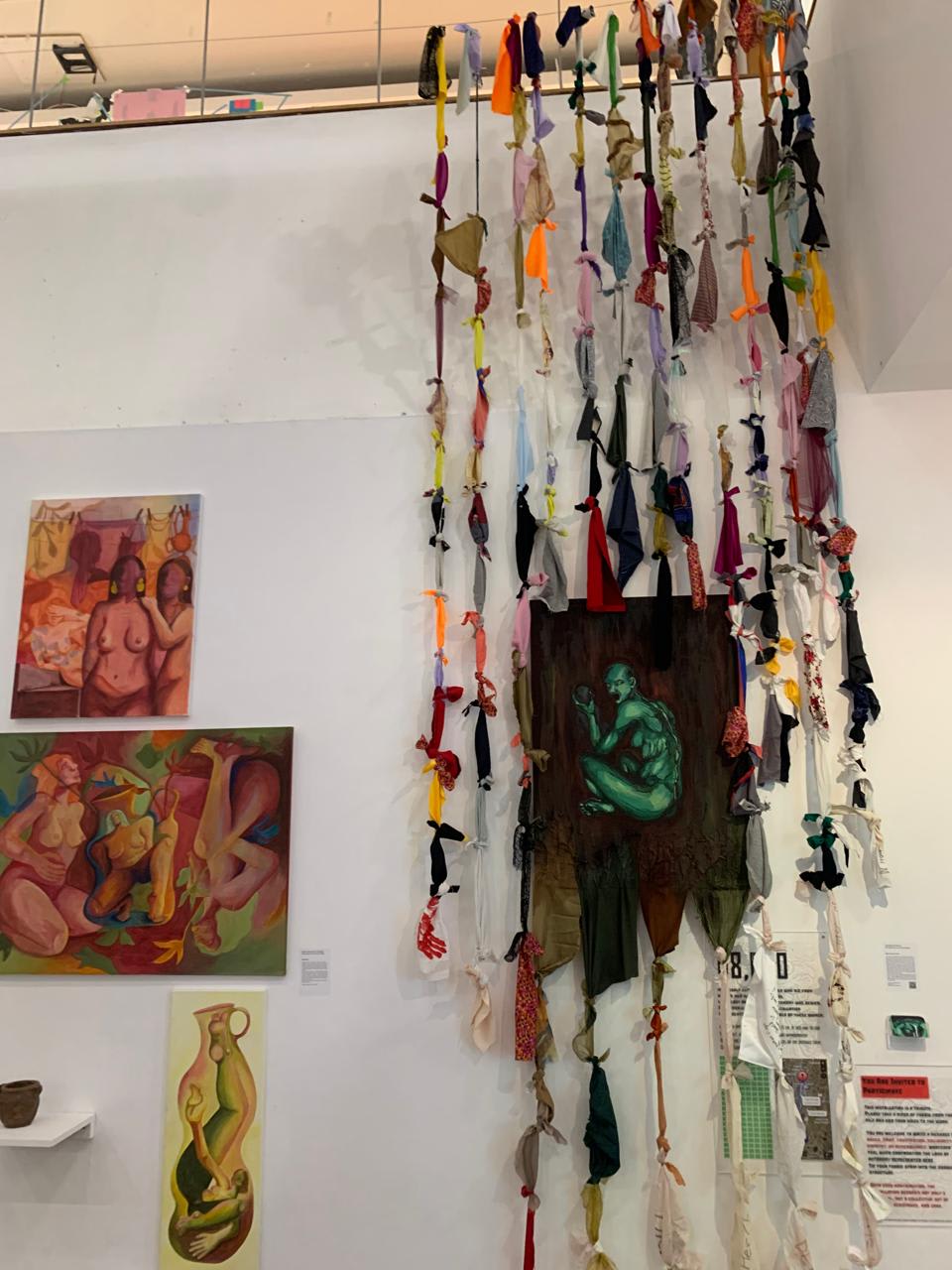 Paintings and cloths hanging on a wall