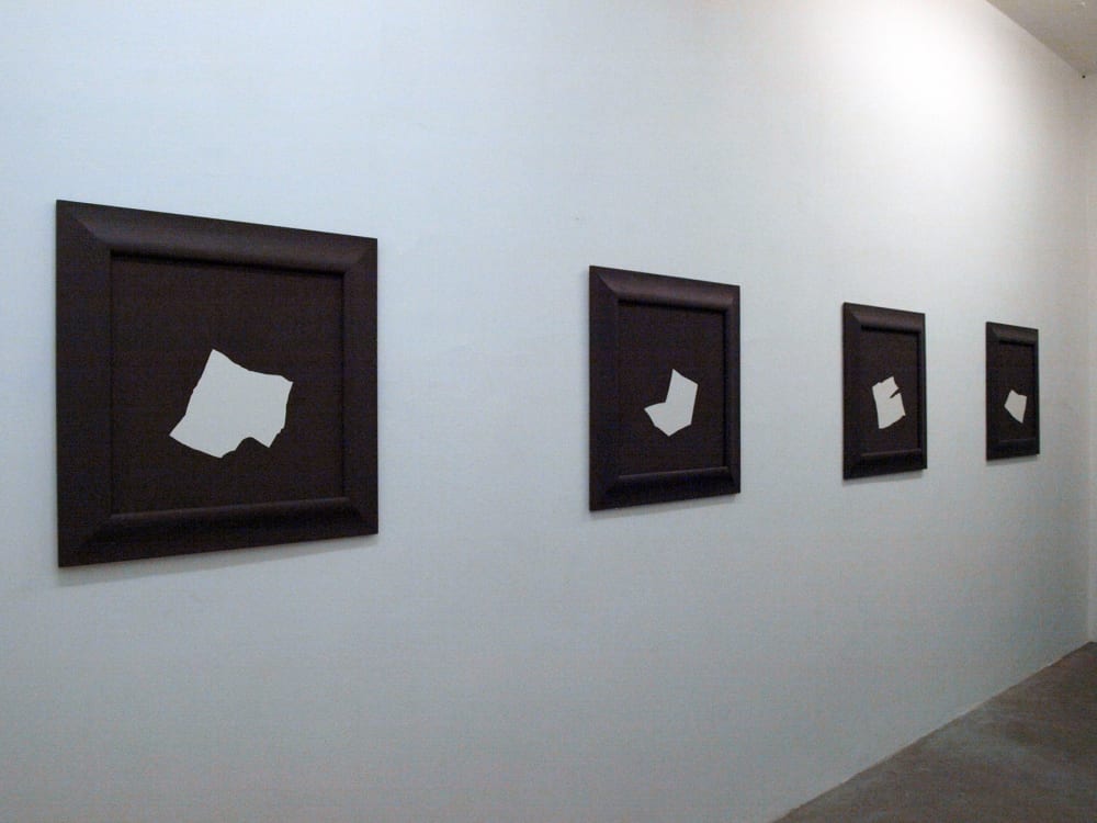 Four black-and-white canvases on a wall