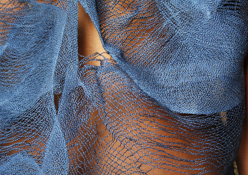 a detailed photo of intricate blue embroidery on an orange background
