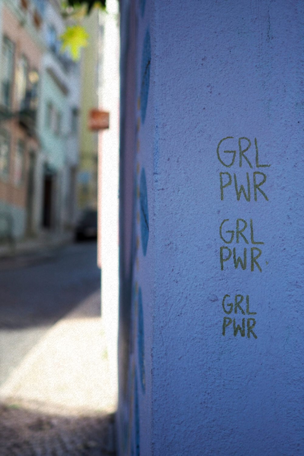 a blue wall with the words 'girl power' written in pen