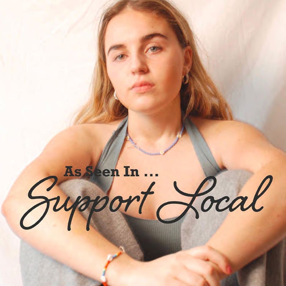 Woman in a grey, halterneck top. With the words 'As seen in Support Local' over the top