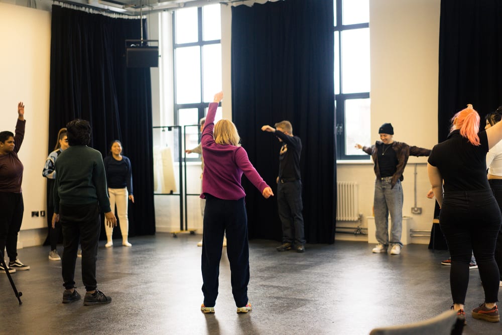 Students standing in a circle preparing for their performance