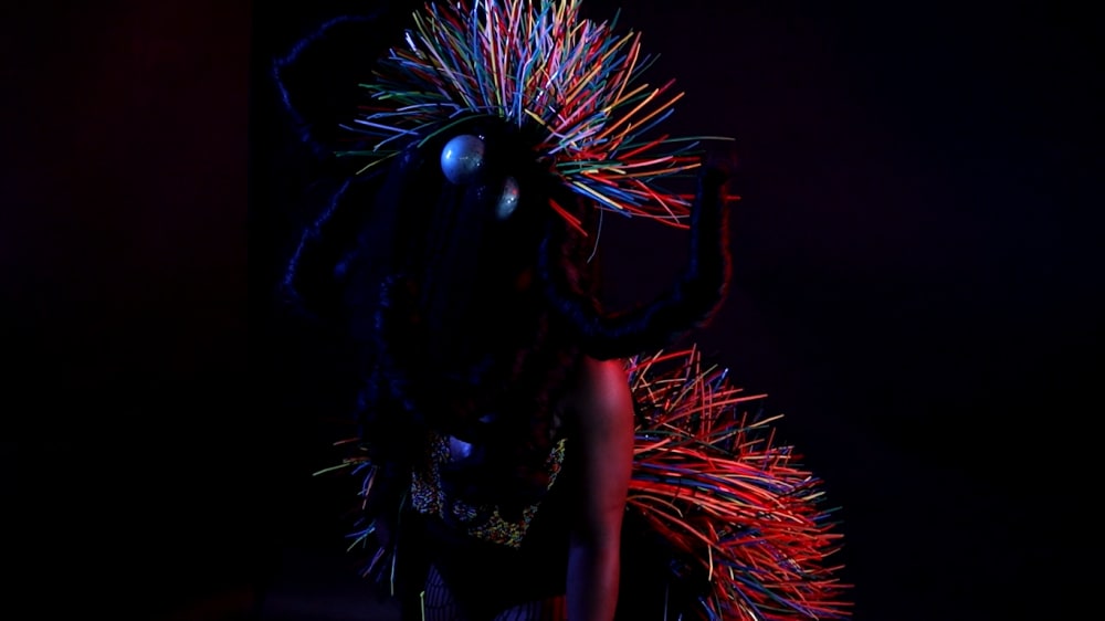 A spider-inspired costume with different coloured cable ties coming out of it.