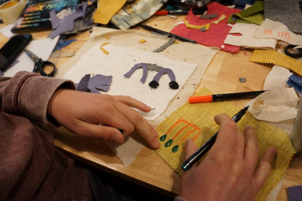 hands drawing and illustrating on a messy table