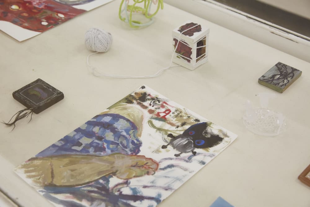 A shot of a table where various small artwork pieces are displayed.