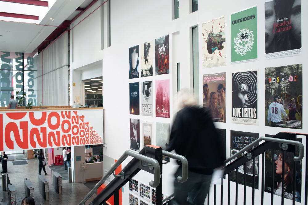 Photo from the top of the stairs at LCC. Guests walking up to the exhibition. 