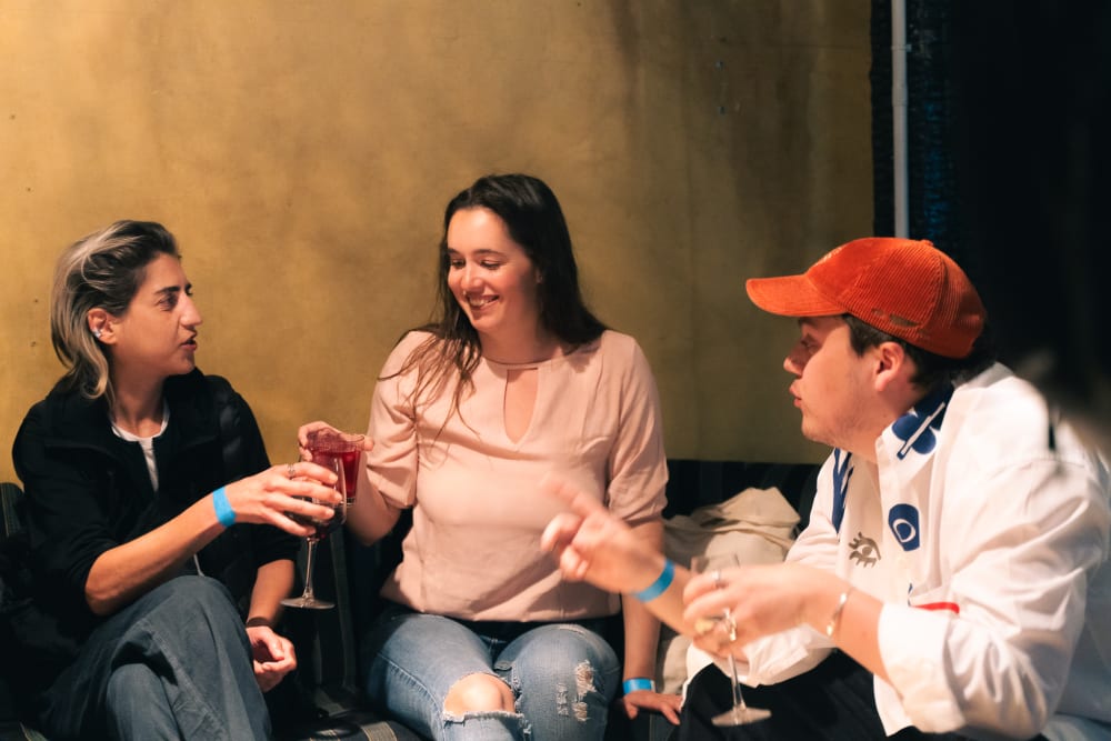Three guests sat on a sofa chatting.