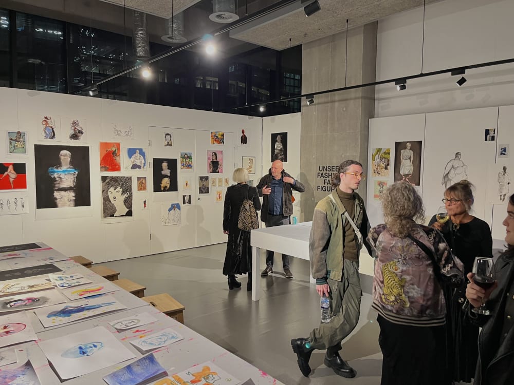 Large gallery space with groups of people chatting.