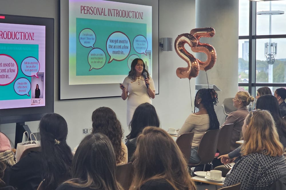 Alex Johnson presenting her placement at Church & Dwight Co, in front of a screen and holding a microphone
