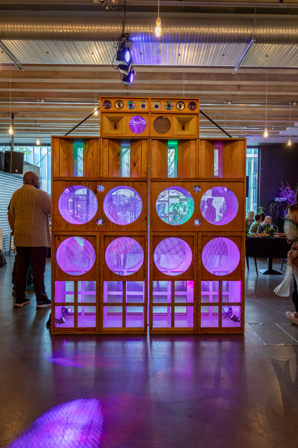 Wooden box speakers with pink and purple lights.