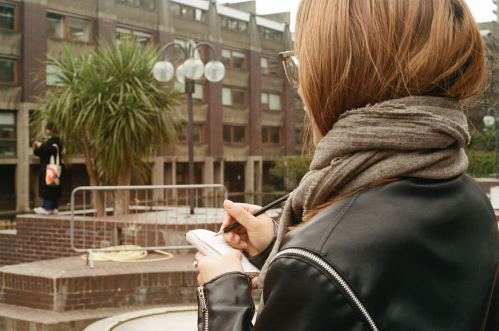 a student sketching in a book