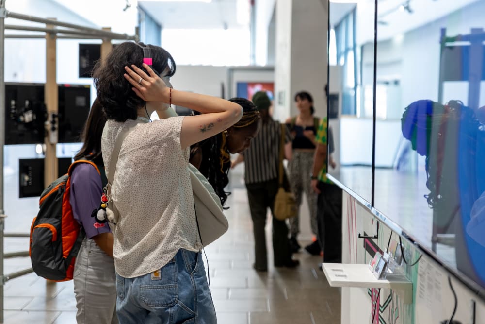 UAL students and alumni looking at the graduates' work