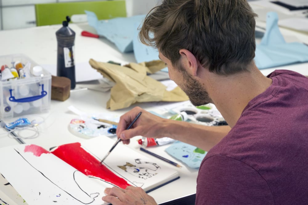 Student painting in a sketchbook