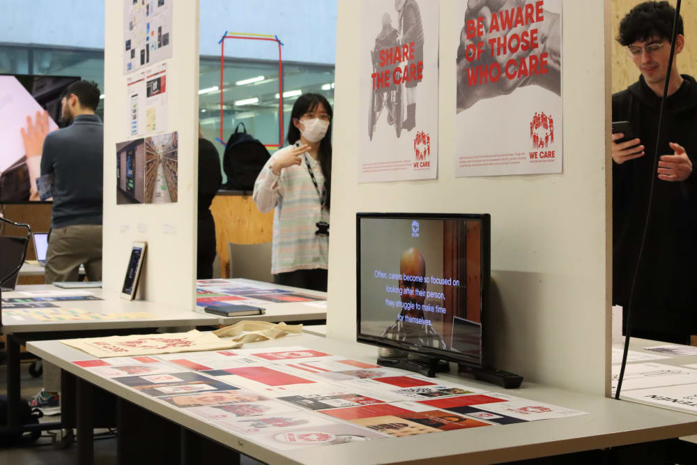 Graphic design examples on a wall and on screen