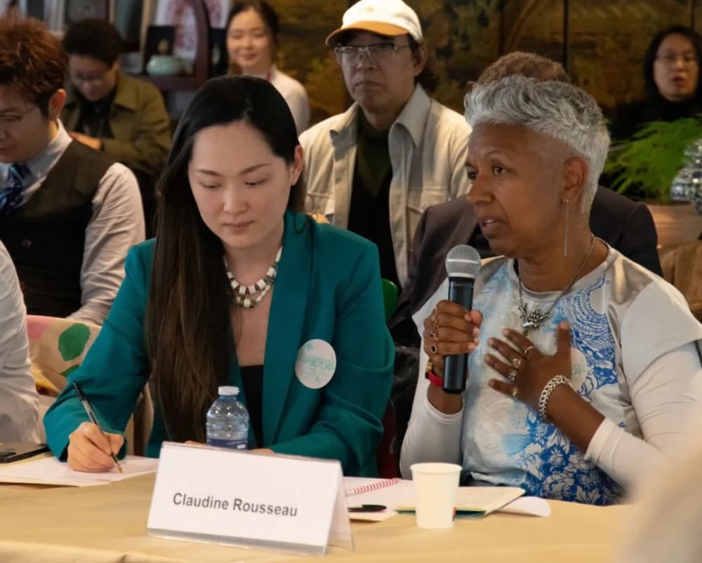 symposium delegates with one person talking into a microphone