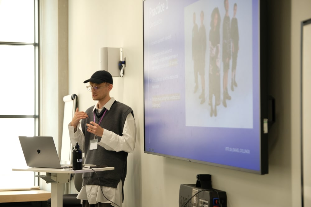 Person standing in a classroom and presenting.