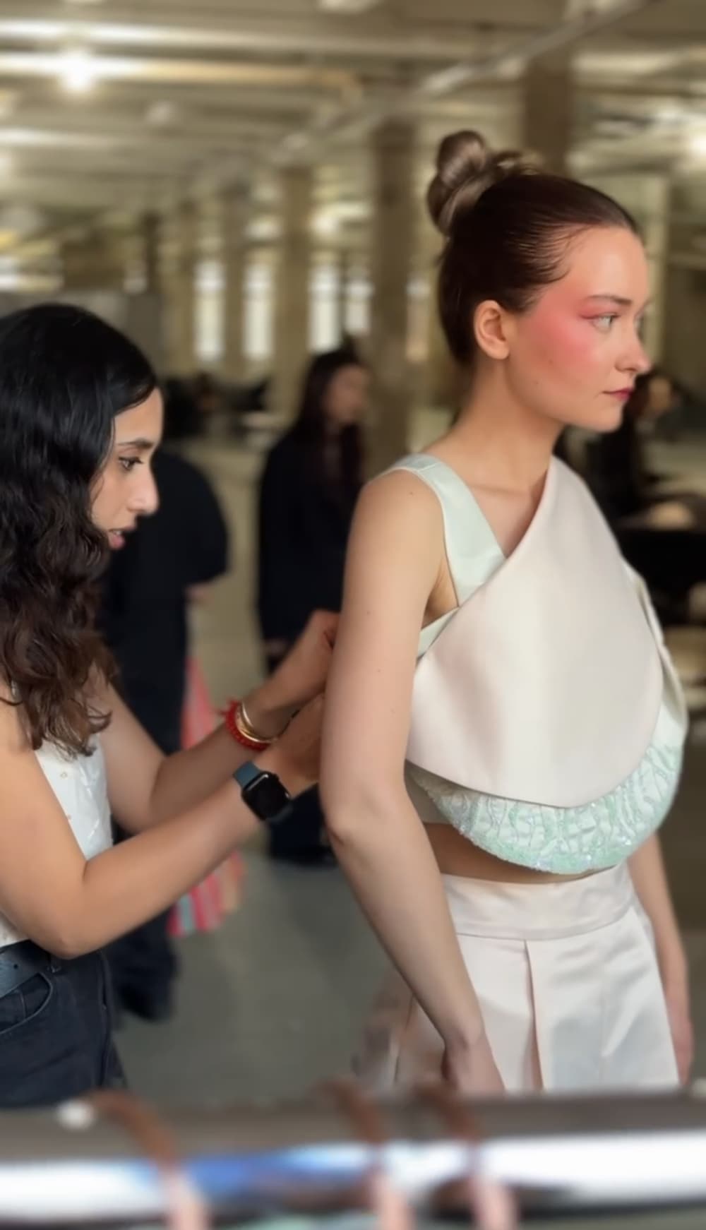 Nayana Kodesia adjusting the fit of a model before a runway at SF Fashion Week 2025