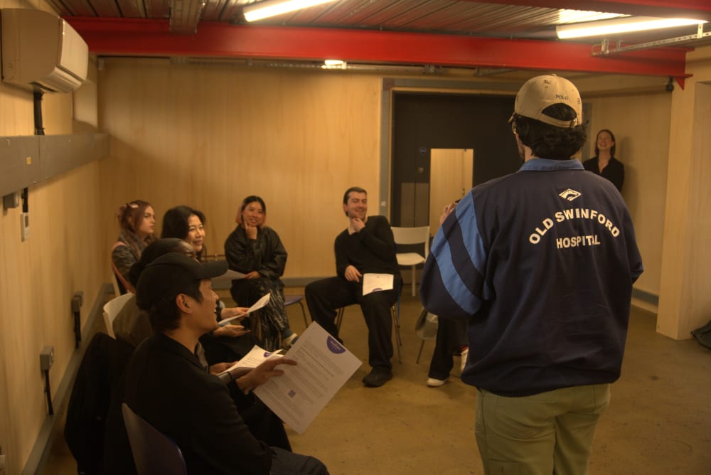People sat on chairs in a room listening to a speaker who is standing.