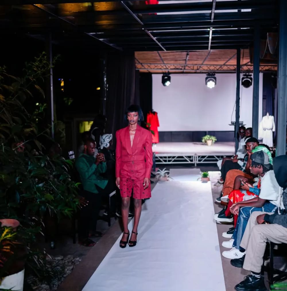 A women walking down a fashion runway with a pink dress on.