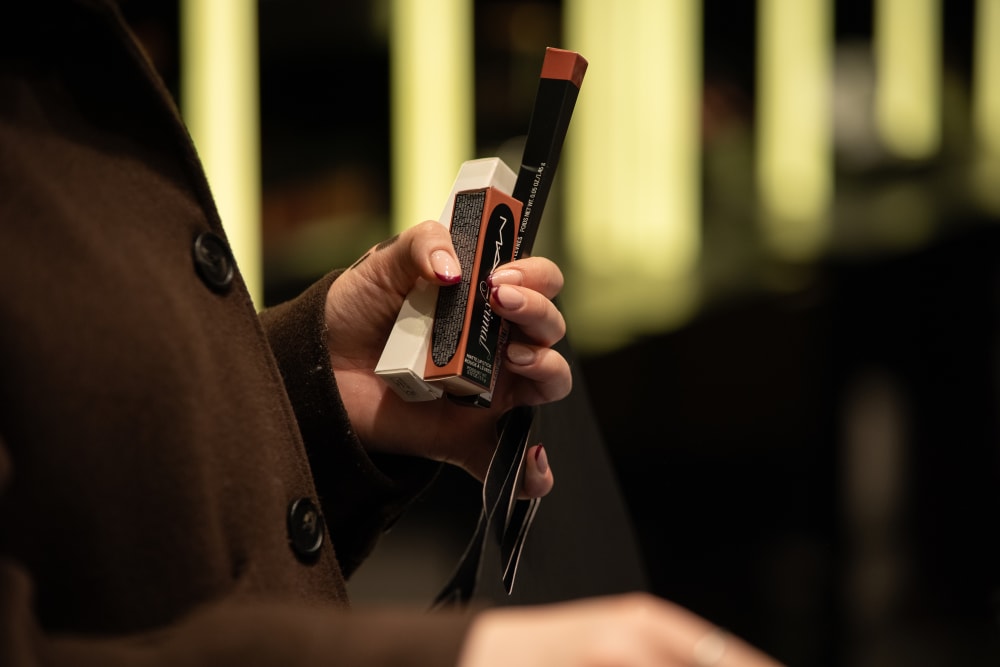 a hand holding mac make up products