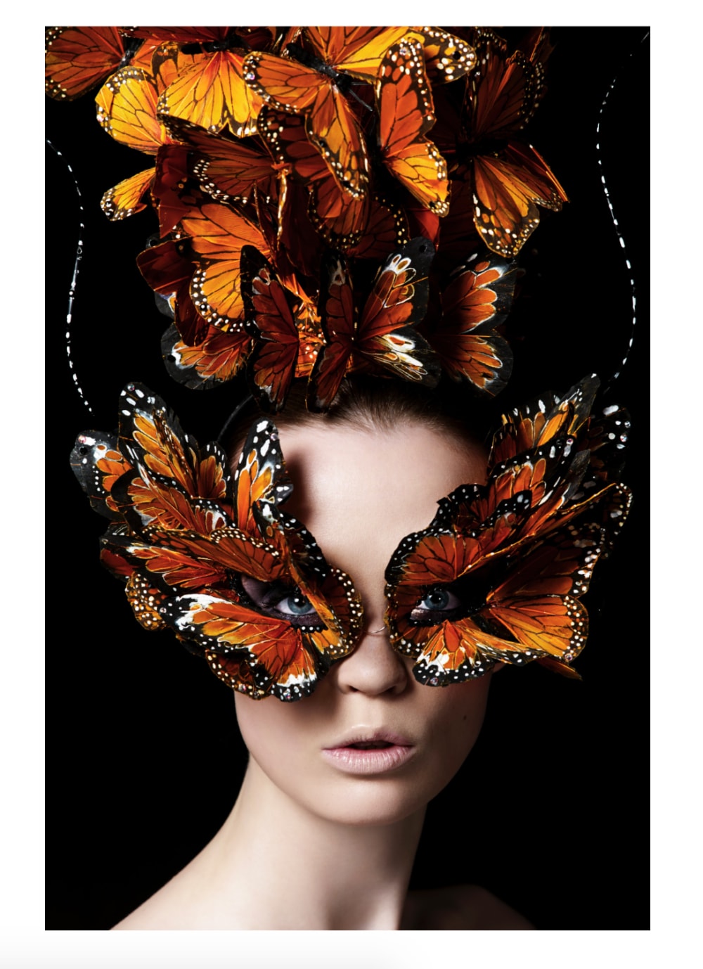 A closeup of a woman wearing a headdress made of butterflies