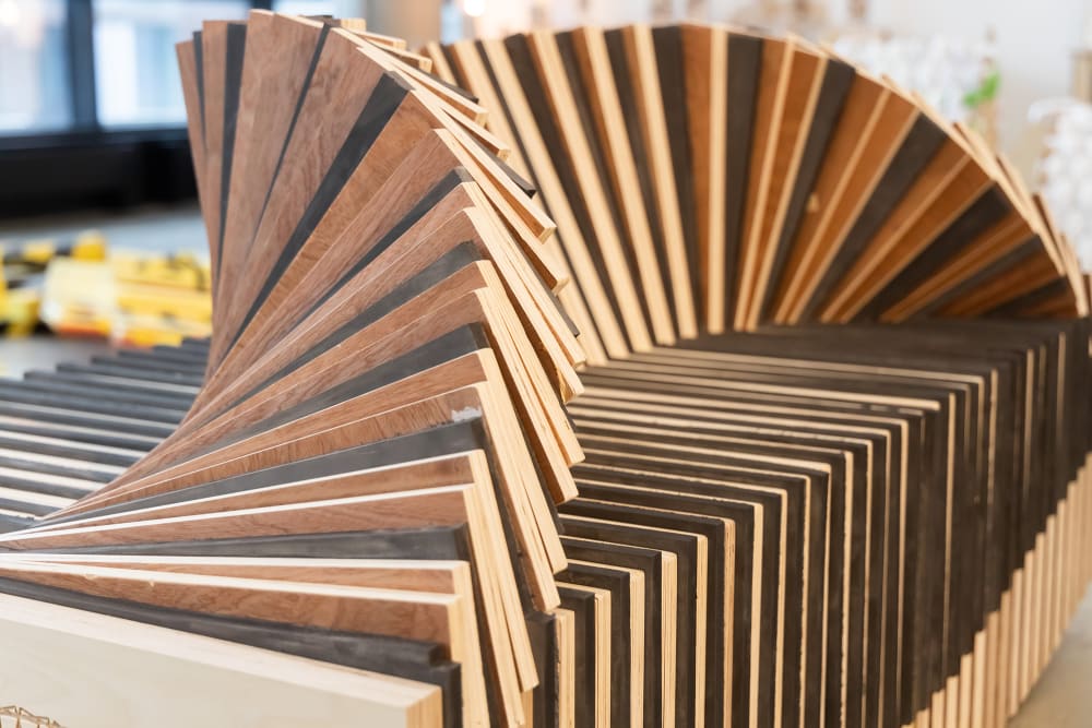 Detail image of a bench with a fan-like structure made with different tones of wood.
