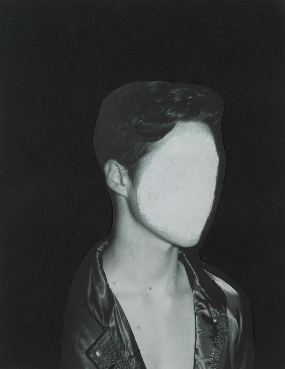 Portrait of a young man in a leather jacket with his face obscured with white paint - by Caroline May.