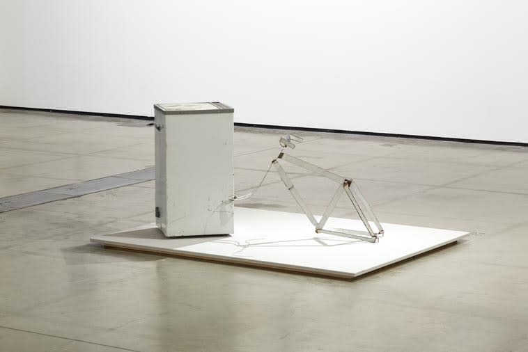 Metal sculpture reminiscent of bicycle and white goods