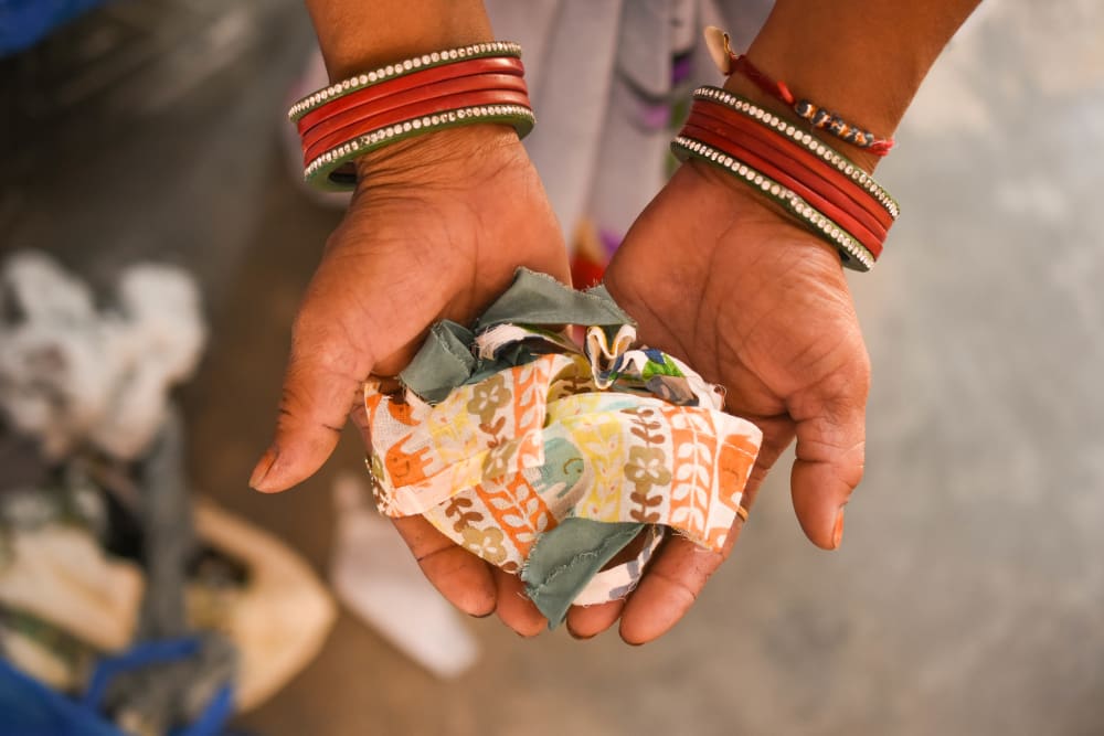 Mutlicoloured fabric being shown to the camera with cupped hands