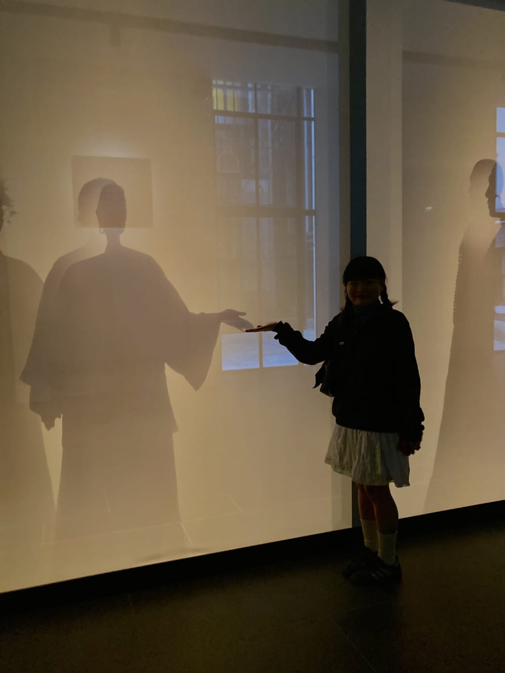Person joining hands with a silhouette at China's Hidden Century display