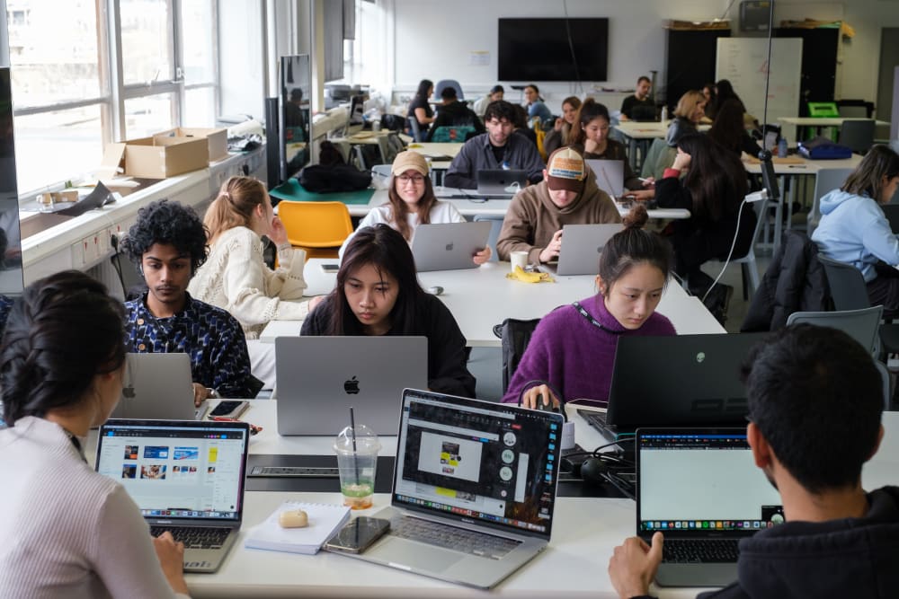 A selection of students working at their laptops.