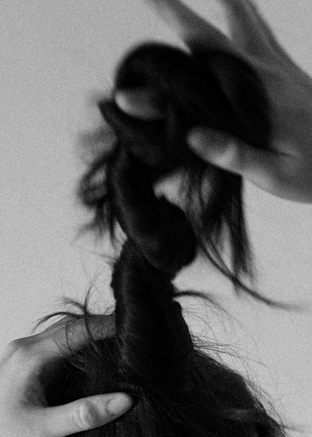 Black and white close up of a hand twisting hair