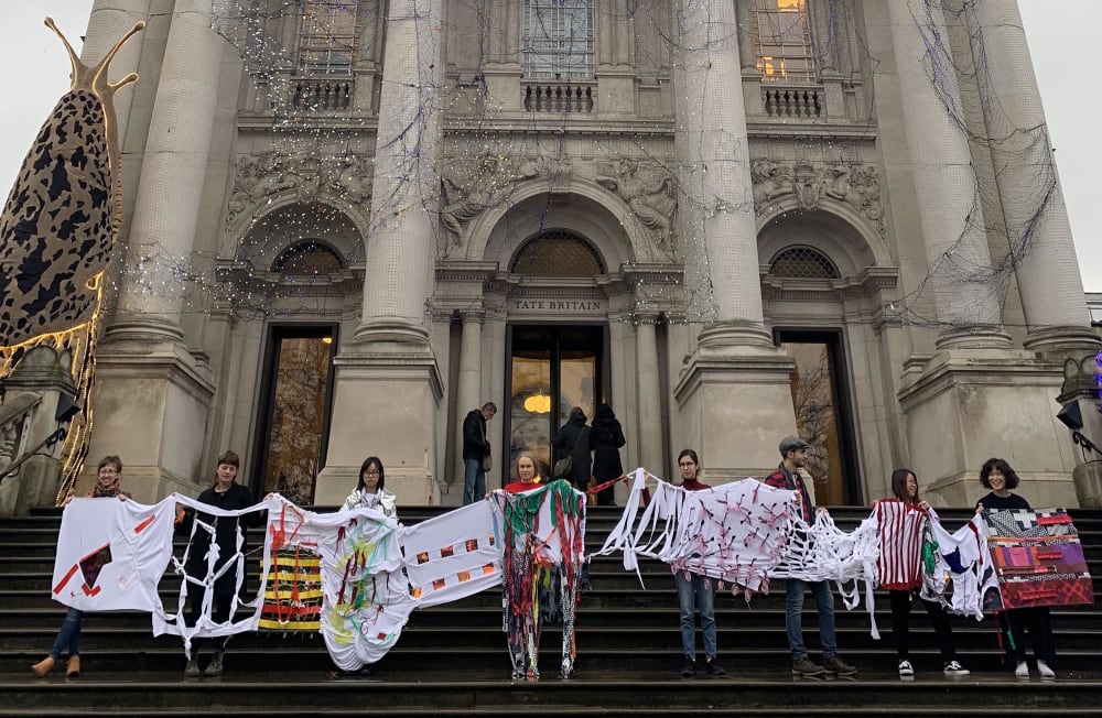 Students holding up their artwork outside Tate Britain