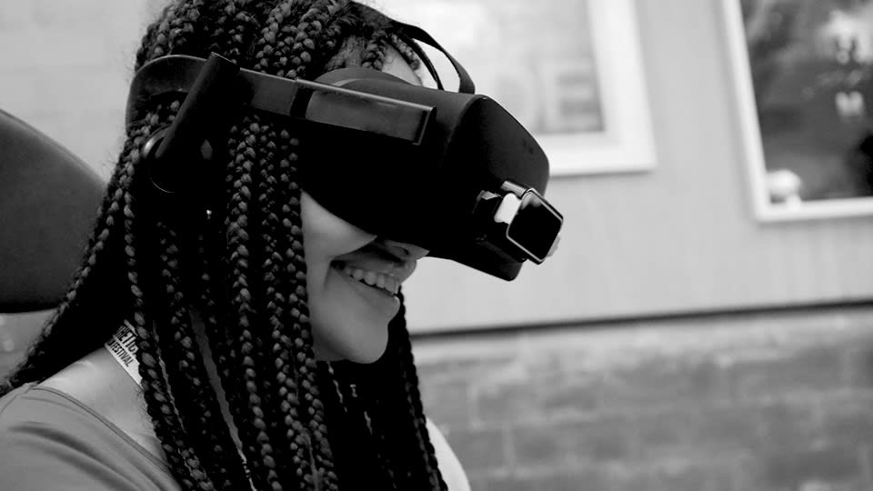 A woman smiling with a VR headset on
