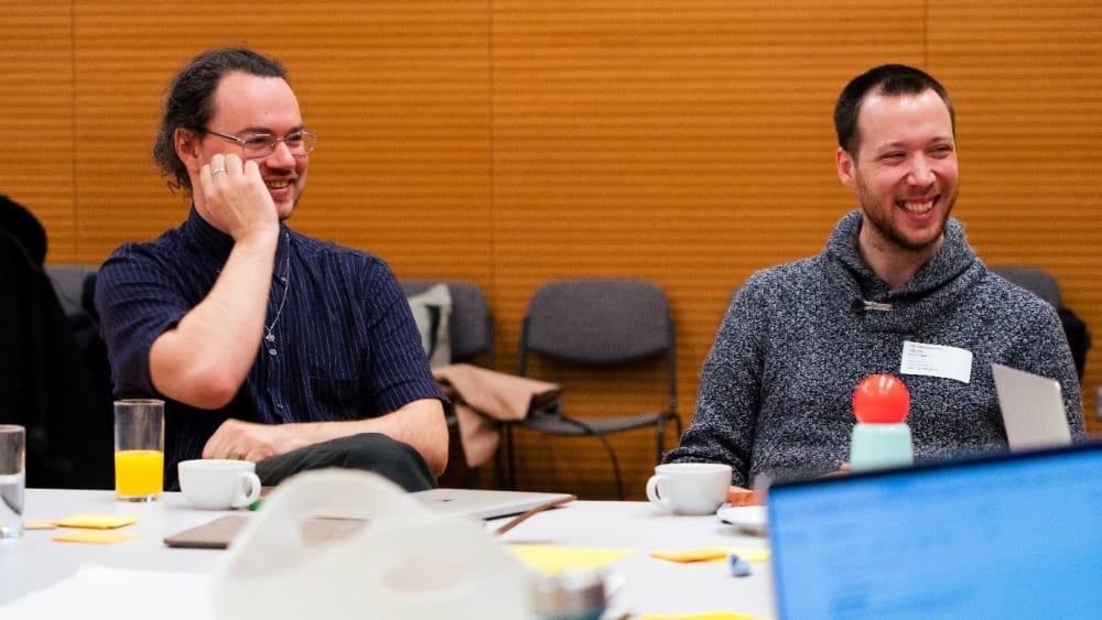 Two people sitting at a table smiling