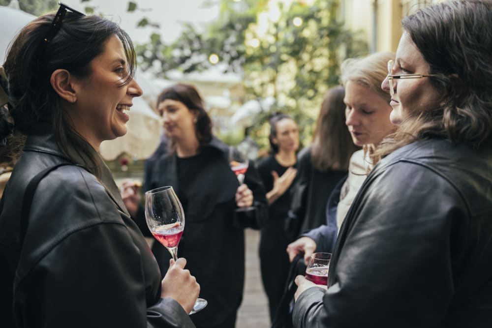 Close-up image of guests standing in a circle chatting