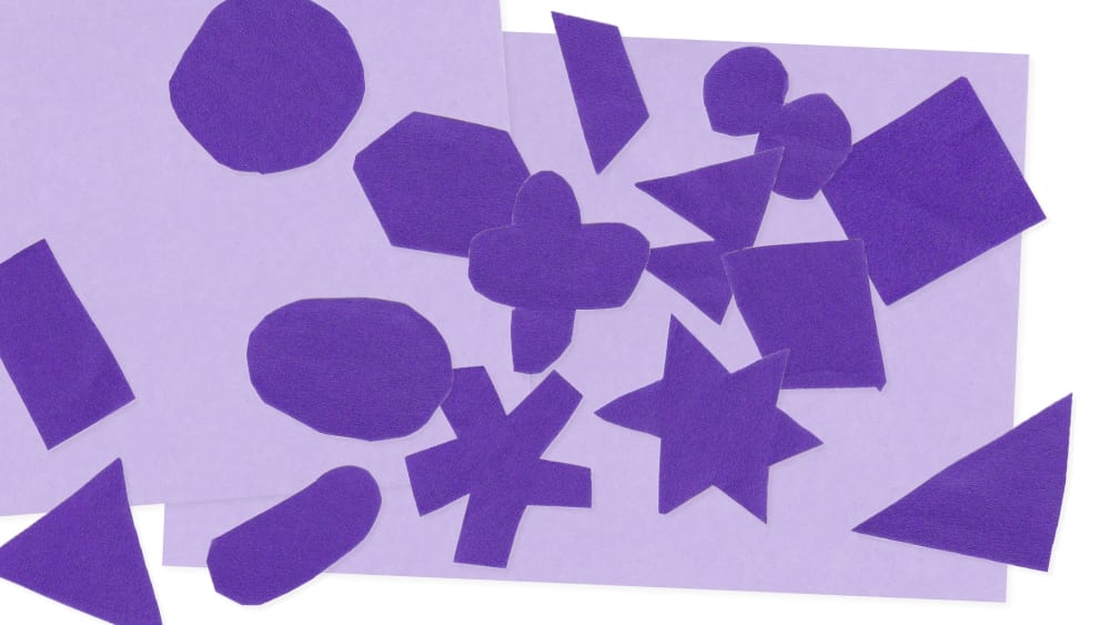 A work-in-progress visual representing the crafting of the Disability history month campaign visuals. A collection of diverse shapes crafted from dark purple paper are scattered across a light purple background