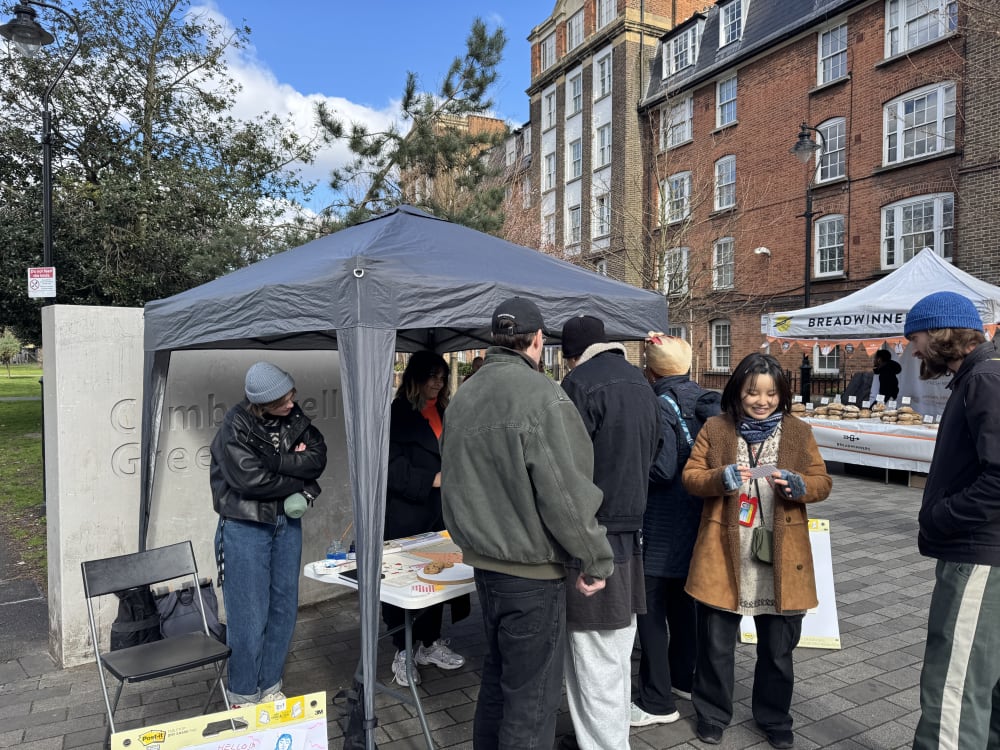 People in front of a tent at a farmer's market