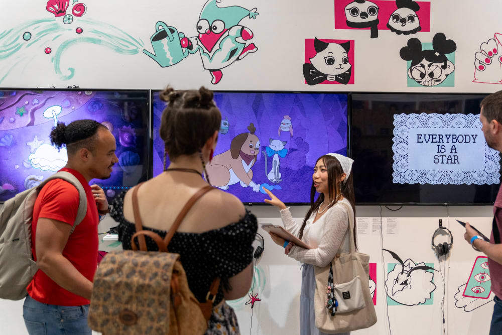 UAL students and alumni looking at the graduates' work