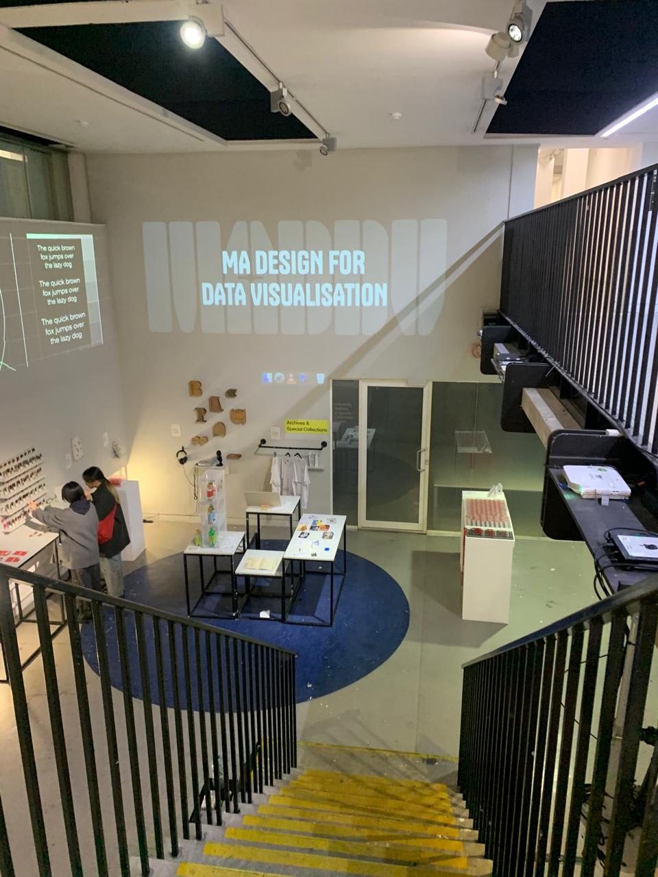 Art show with screens displaying titles 