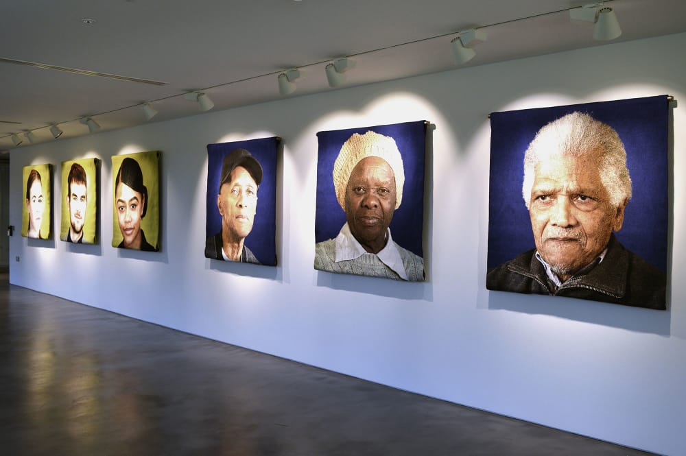 Installation photo of local portraits in the Faisal Abdu'Allah exhibition Facets of a community