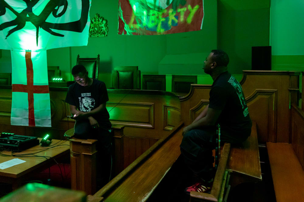 two people sitting in a dark room with a green light