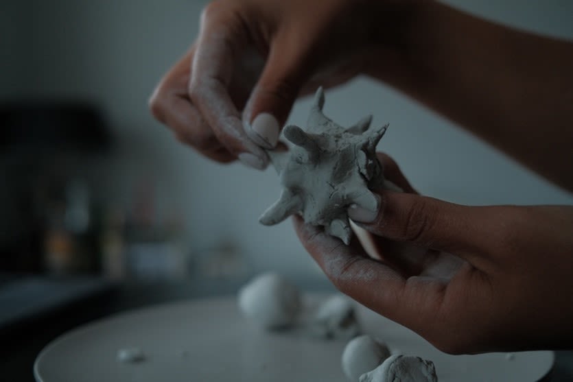 hands hold clay scuplture