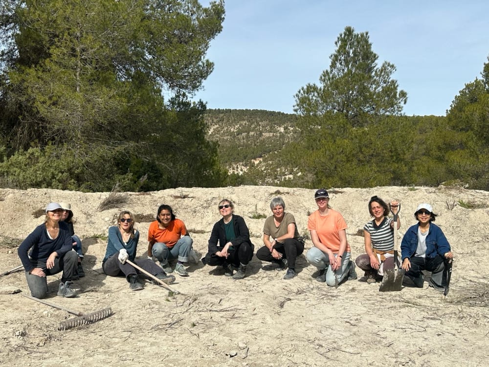 people kneeling and posing for a photo in a desert