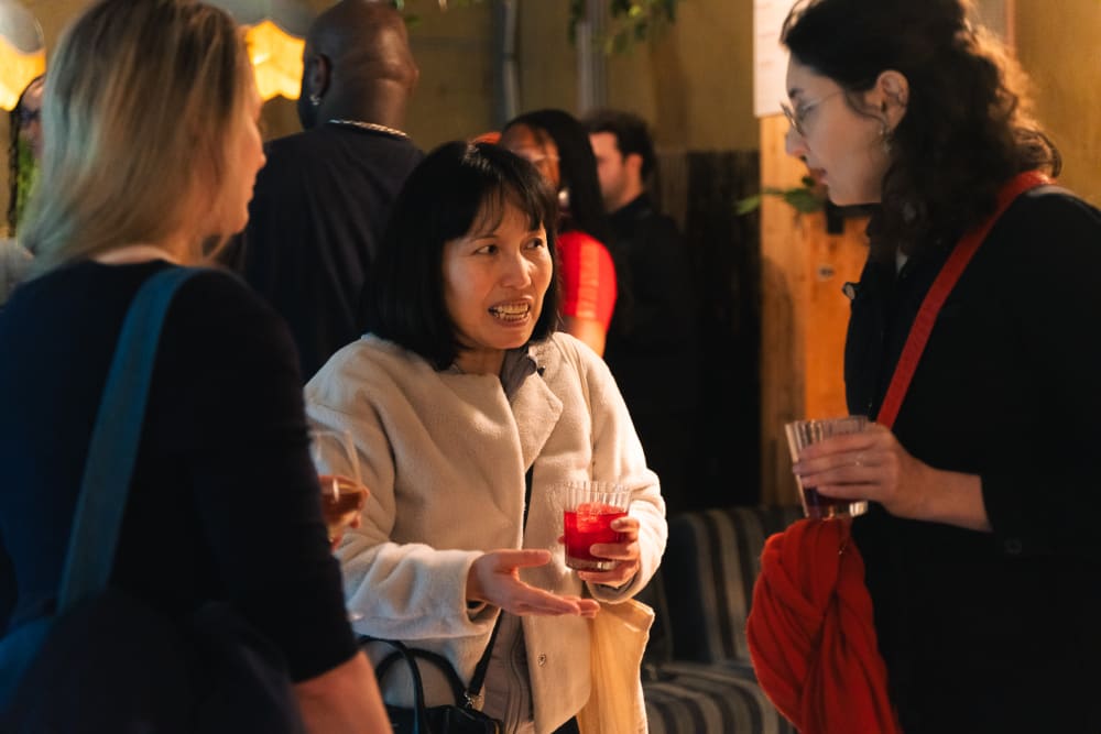 Close-up shot of people chatting in a crowded room. 