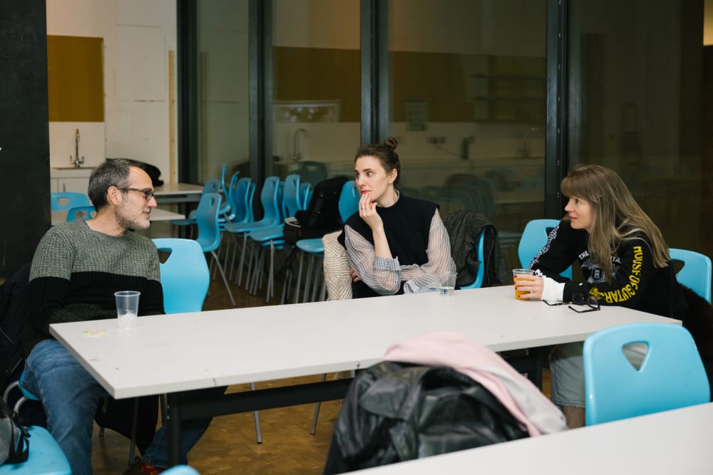 3 guests sat around a table chatting
