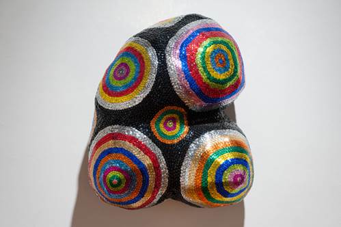 Sequins arranged in multicoloured circular patterns on foam