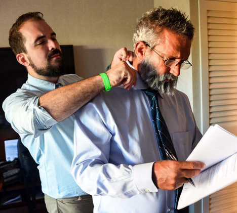 Someone adjusts the person in front of them's collar